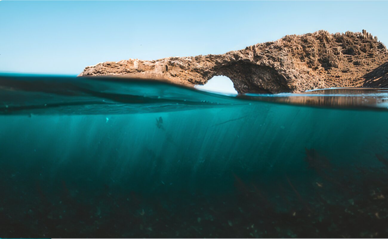 A rock arch above the sea seen at water level