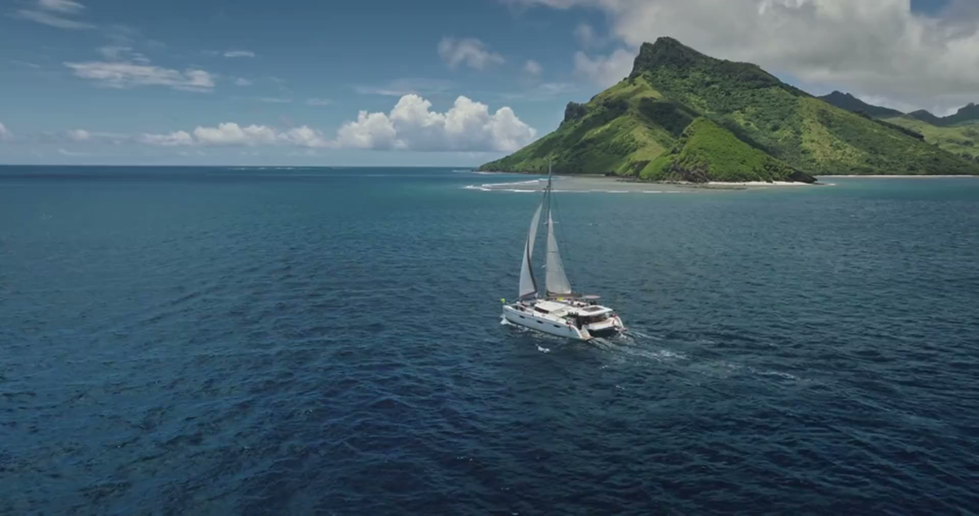 Catamaran sailing along a coastline
