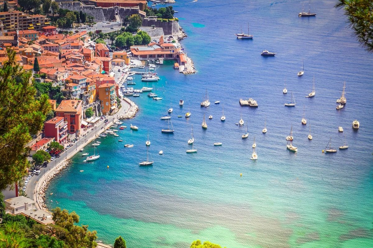 Bay of Villefranche-sur-Mer with sailing boats at anchor and a seaside village