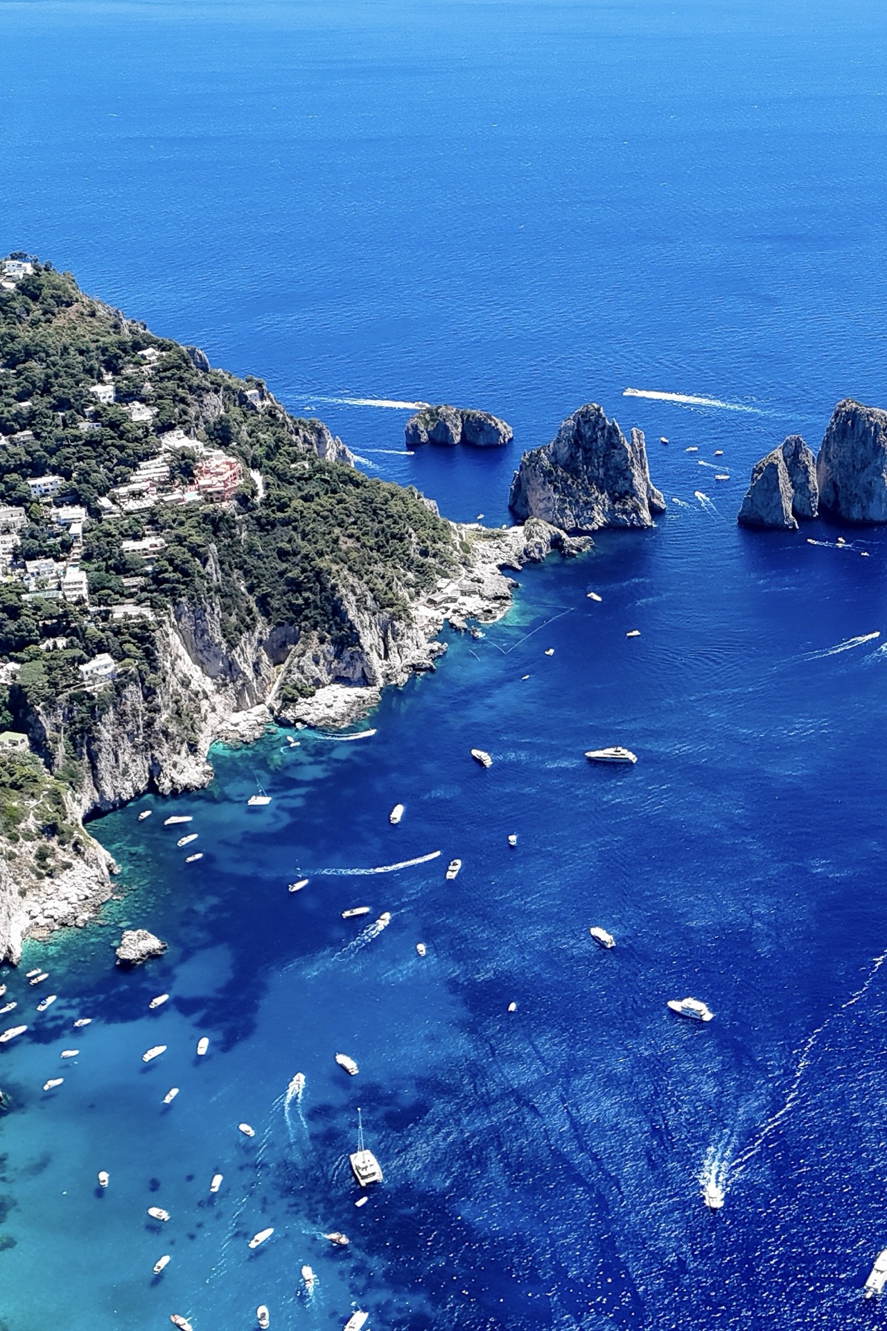 Aerial view of the Faraglioni of Capri with moored boats