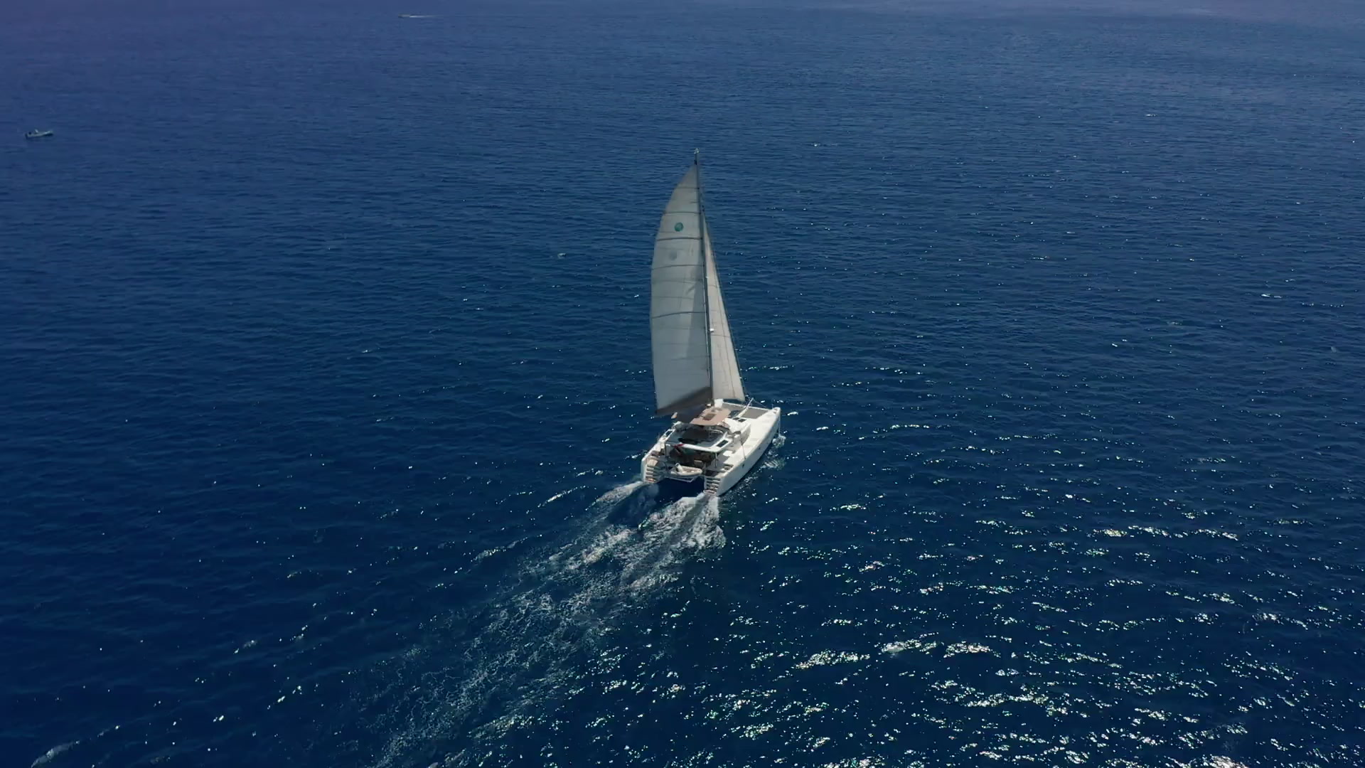 Sailing yacht cruising on calm sea under a bright blue sky